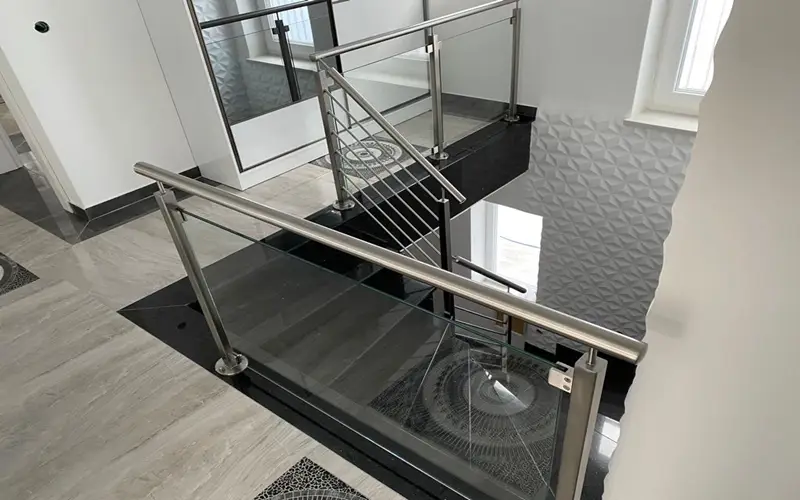 2. Bild Treppengeländer aus Edelstahl mit teilweise waagrecht eingeschweißten Füllstäben und Glaseinsatz